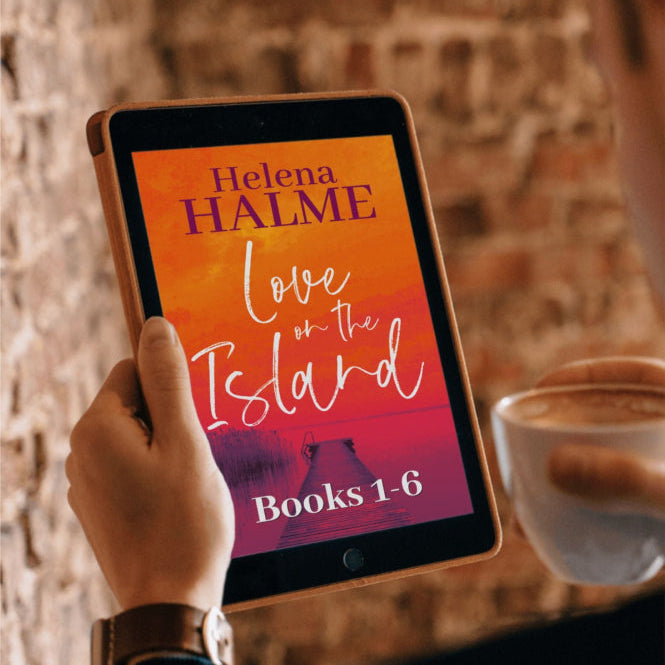Person holding a tablet with 'Love on the Island' book cover displayed, against a brick wall background.