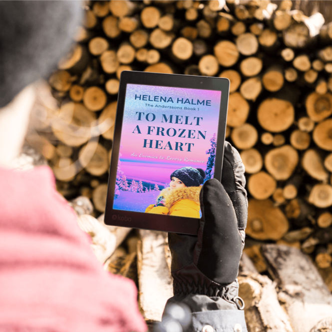 Person holding a tablet with a book cover against a background of stacked logs