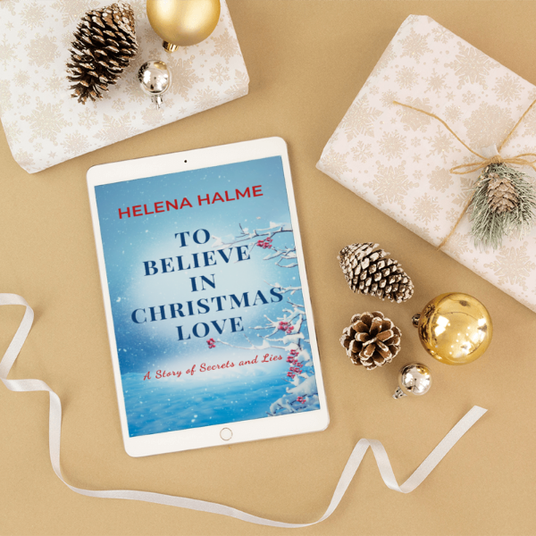 Tablet displaying a book cover titled 'To Believe in Christmas Love' by Helena Halme, surrounded by Christmas decorations on a beige background.