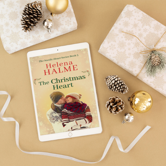 Tablet displaying 'The Christmas Heart' by Helena Halme with Christmas decorations on a beige surface